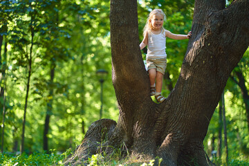 a child in the park playing next to a big tree, the concept of ecology and good humor
