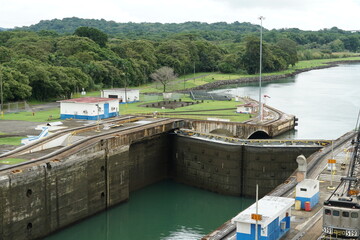 Fototapeta na wymiar Close gates or doors of Gatun locks in Panama Canal from Atlantic side. Level of water inside lock is lower than the in ocean. There are also visible rails.