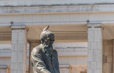 A pigeon sits on the head of the Dostoevsky Monument July 01, 2022 Moscow
