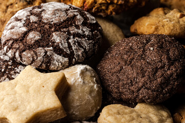 close up of christmas cookies, with chocolate, ginger, sugar, walnut, powdered sugar on wooden table