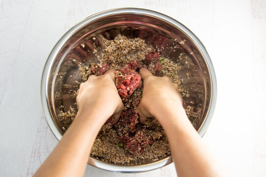 Kibe - Woman mixing kibbeh recipe in a silver bowl - brazilian, arabian, lebanese, syrian meat appetizer food