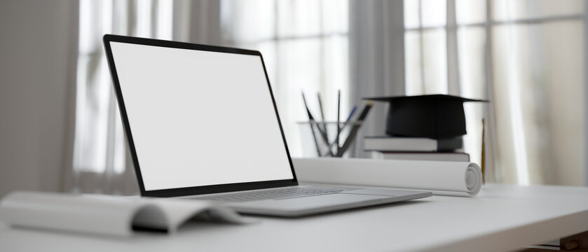 Close-up, Modern College Student Working Desk With Laptop Computer, Stationery And Academic Cap.