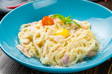 Spaghetti Carbonara with bacon on wooden table