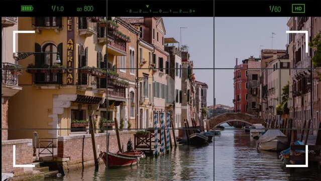Venice, Italy - July 1, 2022: A look through the photo camera Venice narrow canal with historical buildings. Landscape of summer sunny day
