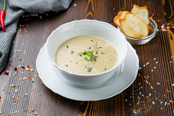 cream of porcini mushroom soup with croutons on wooden table