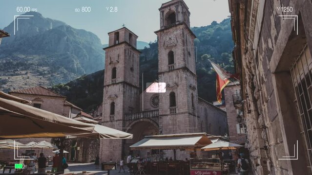 A look through photo camera at Cathedral of Saint Tryphon in Kotor, Montenegro is one of two Roman Catholic cathedrals in Montenegro. Summer landscape with mountain and sky in sunset time