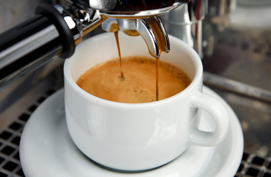 Pulling double espresso shot from E61 espresso machine in to white coffee cup