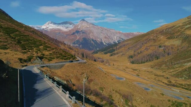 Aerial view across scenic alpine mountain countryside serpentine Spl&uuml;gen pass road in Switzerland