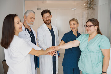 Group of professional medical team of doctors putting their hands together