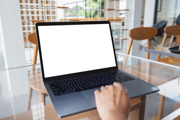 Mockup image of a woman working and touching on laptop touchpad with blank white desktop screen in cafe