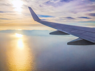 View from the plane window on the island of Tenerife in the Atlantic Ocean at dawn. The wing of an...
