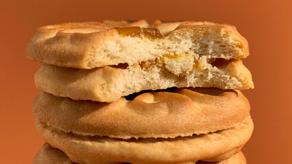 stacks of jam biscuits are bitten on the orange studio background