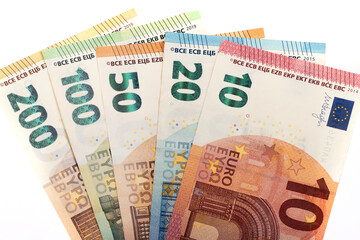 Euro banknotes of various denominations on a white background