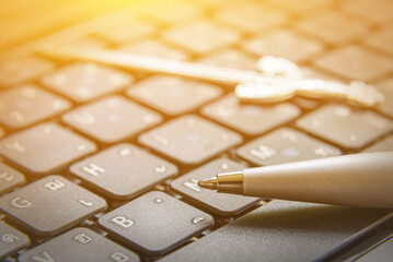 The pen is mightier than the sword concept : Ballpoint pen and a sword on a laptop. This proverb or...