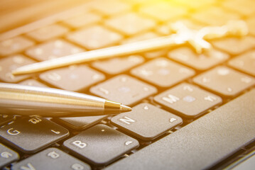 The pen is mightier than the sword concept : Ballpoint pen and a sword on a laptop. This proverb or phrase is a metonymic adage, indicating that a journalist can report lie or truth using only a pen. - obrazy, fototapety, plakaty