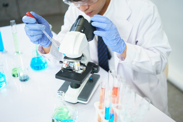 Fototapeta premium Asian scientists are seriously studying the chemical composition in the laboratory. Specializing in Young Biotechnology Use advanced microscope equipment.