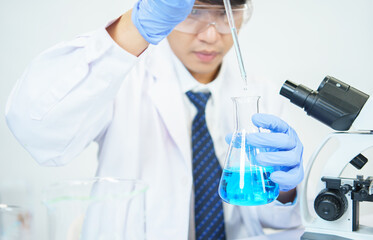 Fototapeta premium Asian scientists are seriously studying the chemical composition in the laboratory. Specializing in Young Biotechnology Use advanced microscope equipment.