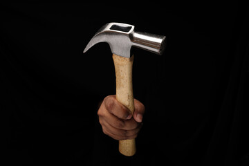 Asian male dark skinned single hand fist finger on black background holding using hammer