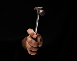 Asian male dark skinned single hand fist finger on black background holding using hammer