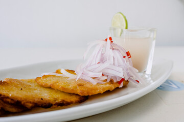 Peruvian food: Corn cakes with spicy onion sarsa and lemon juice.