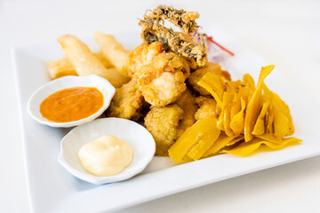 Peruvian food: chicharron de pescado or fish cracklings with fried cassava and onion salad with...