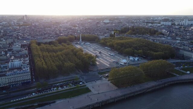 Aerial circling over Bordeaux Place des Quinconces cityscape at sunset