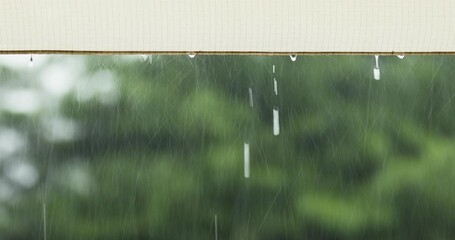 Raindrops form on the tarp and fall