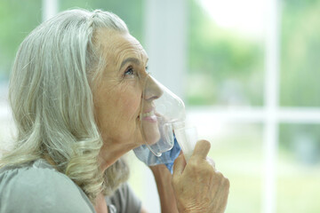 Portrait of an elderly woman using an inhaler