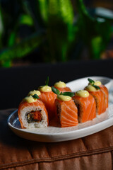 sushi roll philadelphia with salmon in a plate in female hands