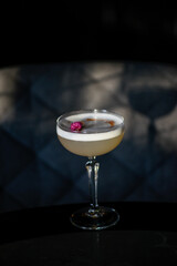 Sauer alcoholic cocktail with foam on a dark background