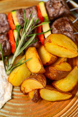 kebab on skewers in a plate with potatoes macro photo