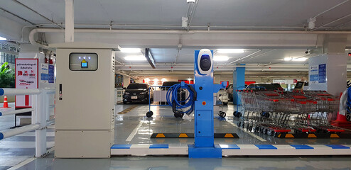 Bangkok, Thailand - March 25, 2022: Blue charging points station for electric car with charger and...