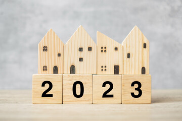 2023 Happy New Year with house model on table. Banking, real estate, investment, financial, savings and New Year Resolution concepts