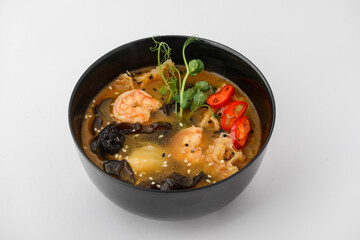 Thai dish soup with shrimp on a black plate