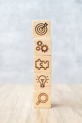 wood block with business goal, strategy, target, mission, action, objective, teamwork, research and...