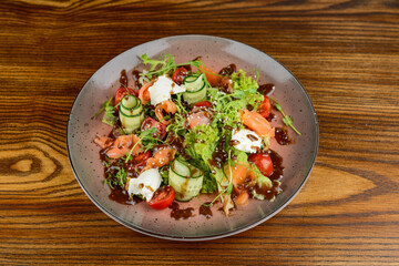 fresh salad with salmon in a brown plate