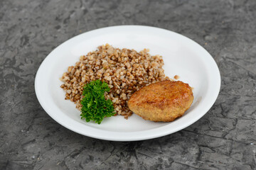buckwheat porridge with cutlet on a white plate