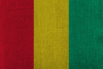 Patriotic classic denim background in colors of national flag. Guinea