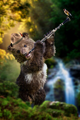 Bear cub plays a wind instrument in the middle of the forest in a hat on the background of a...