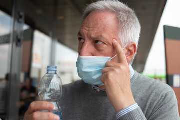 Man drinking a bottle of water during coronavirus pandemic