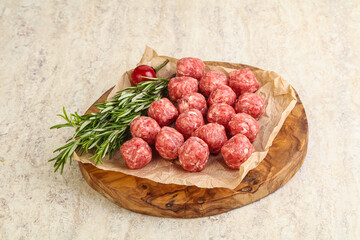 Raw uncooked beef meatballs served rosemary