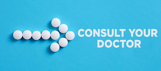 Arrow shape made of medical pills pointing to the word consult your doctor.