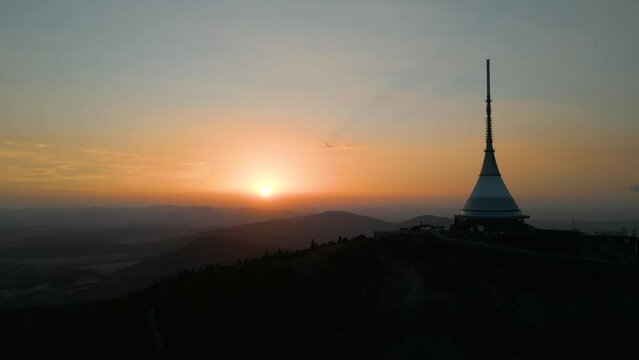 Silhouette of Jested Tower, Hotel, Restaurand and TV Tower in Liberec Czech Republic with sun setting in background