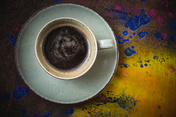 Mug of hot coffee on a wooden board