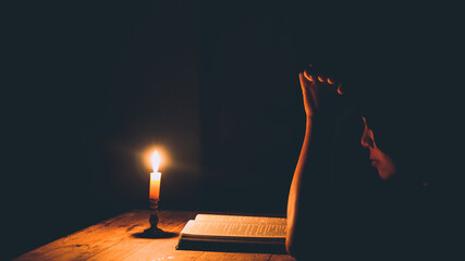 Woman praying in the light candles