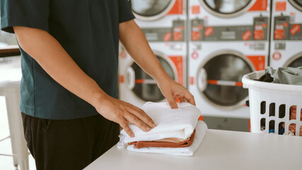 House husband with Basket and dirty laundry washed clothing in laundry room interior. washing machine at laundry business store