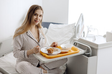 a woman hospitalized has lunch, woman eating in hospital. - obrazy, fototapety, plakaty