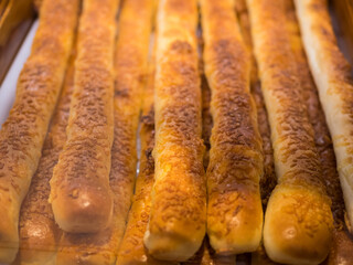 Close-up view of the chesse stick breads on a tray and selling in the bakery shop.