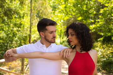 Handsome young man and woman dancing bachata and salsa in the park. The couple dance passionately...