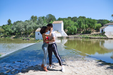 beautiful woman and handsome man latinos dancing bachata are dancing by the river in the forest....